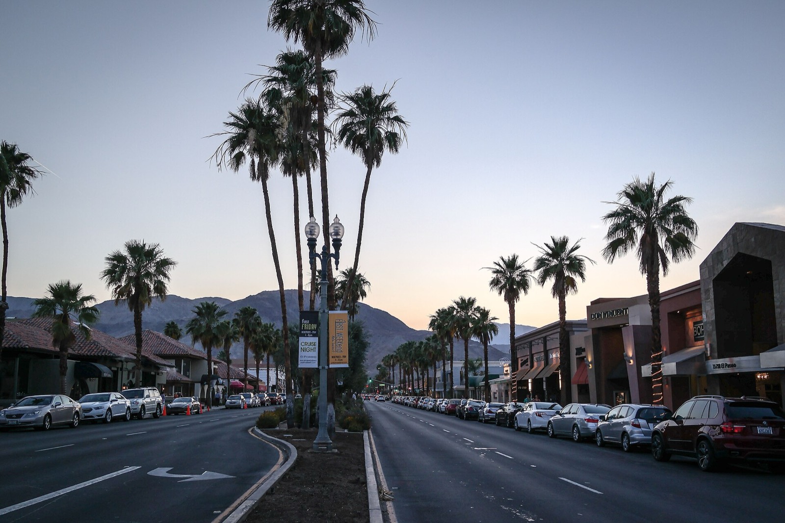 El Paseo in Palm Desert, California, at dusk with palm trees and the mountains behind